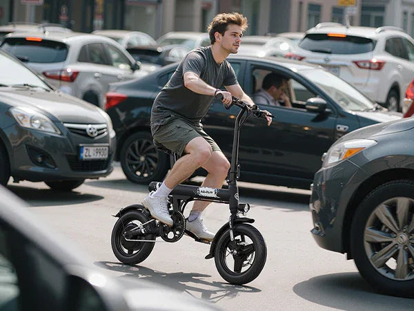 Young man riding black electric bike through busy urban street with cars around