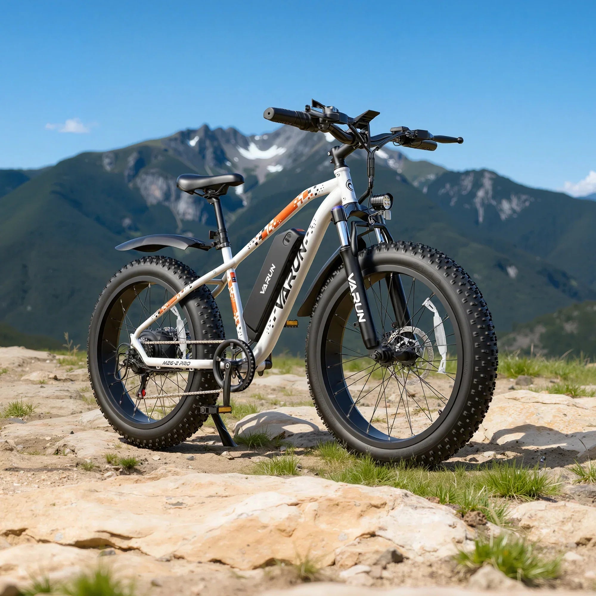 White Varun fat tire electric mountain bike on rocky terrain with green mountains in background