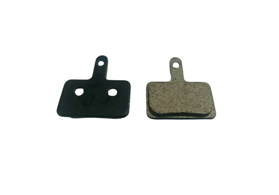 Two rectangular bicycle disc brake pads with mounting tabs on a white background